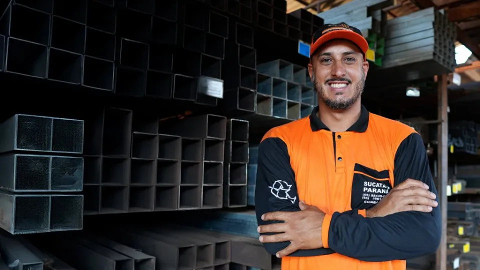 Funcionário do Sucatão Paraná em frente ao estoque de metalon